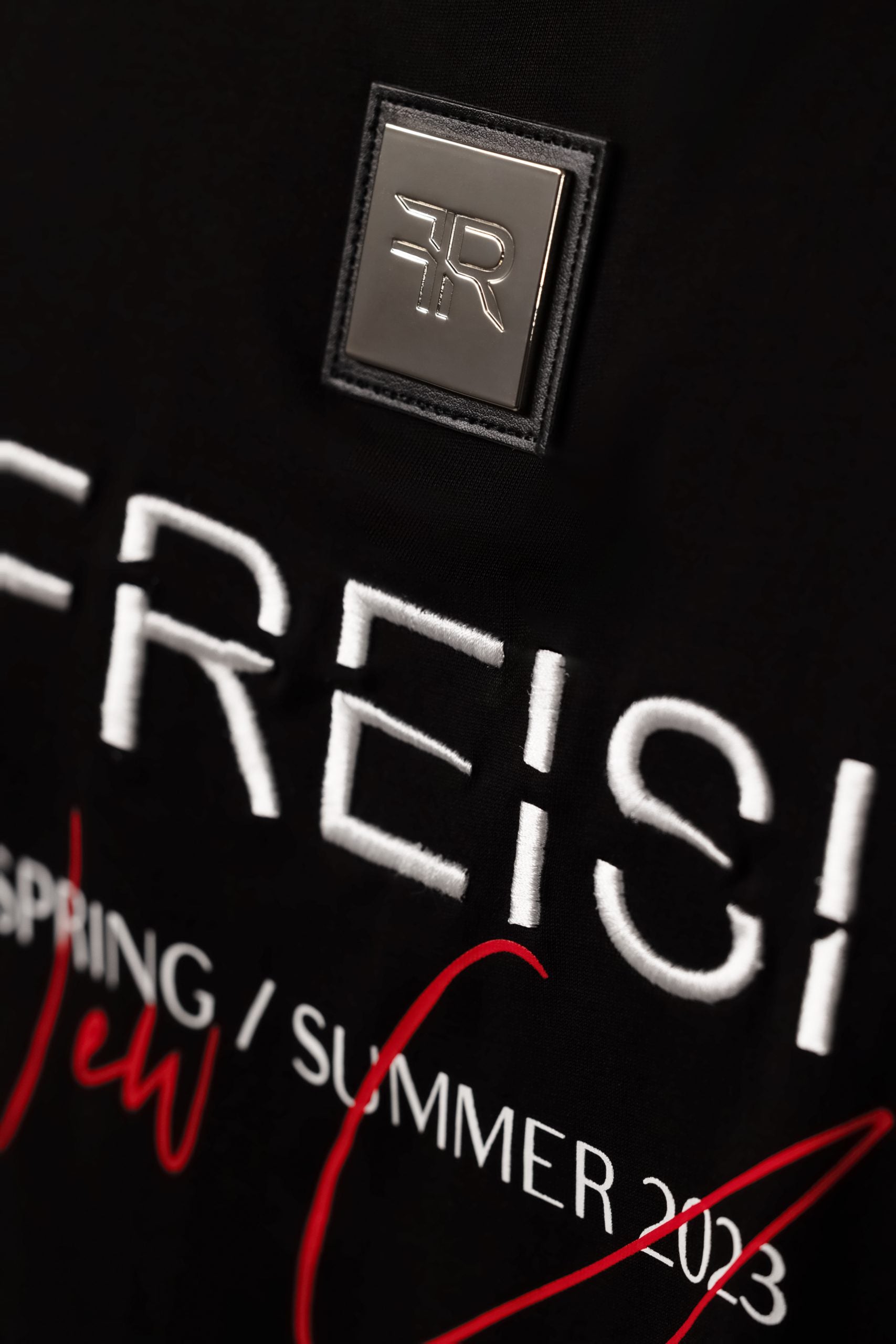 A branded gold metal and leather label on the reverse, close to the embroidered FREISI logo, marks this T-shirt as a symbol of authentic craftsmanship and sophistication